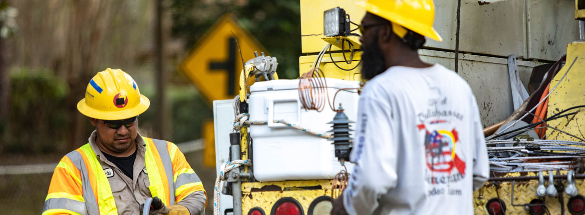 Utility crews working to fix a broken pole