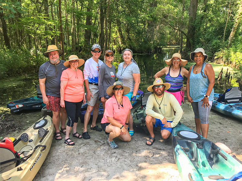 A group of seniors on the bank of a river.